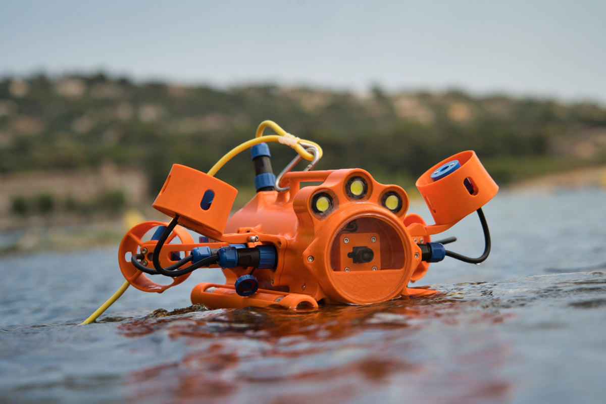 Drone sous-marin BentiX posé sur des rochers au bord de l'eau salée