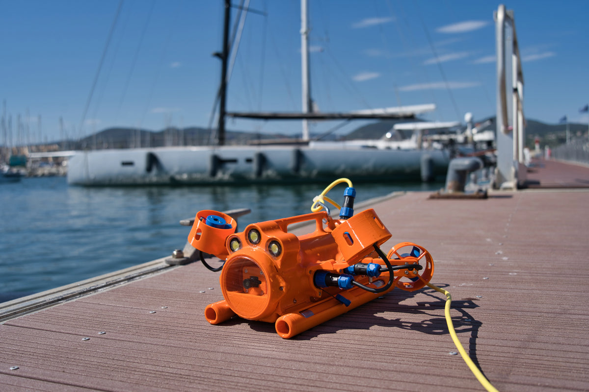 Drone sous-marin BentiX relié à son câble ombilical sur un ponton de port de plaisance, prêt pour une inspection