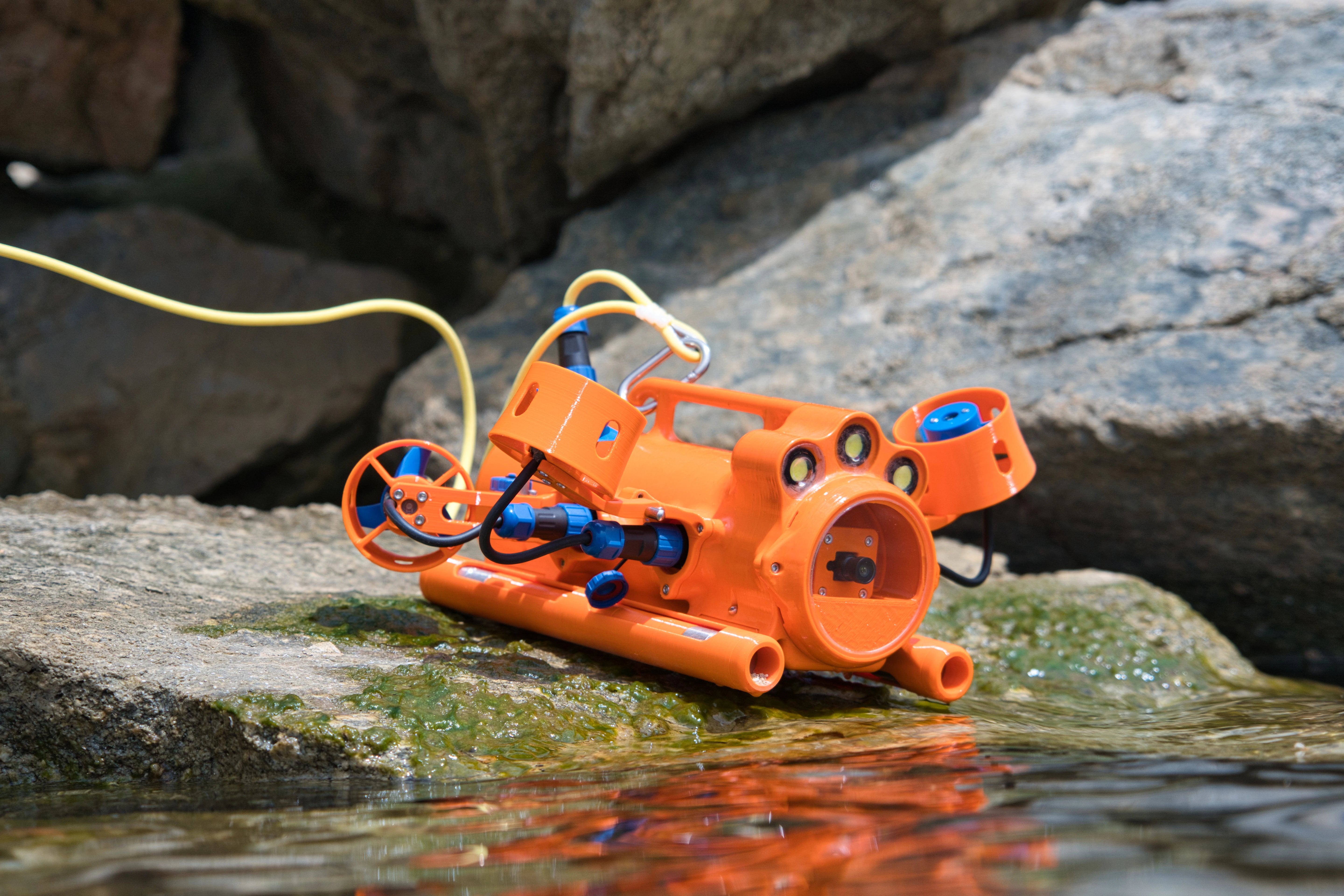 Drone sous-marin BentiX posé sur un rocher au bord de l'eau, prêt à être mis à l'eau