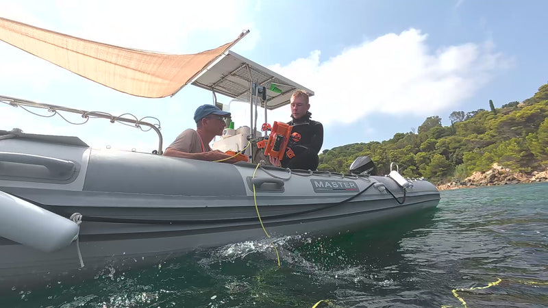 Opérateur seul mettant à l’eau un drone sous-marin BentiX depuis un bateau